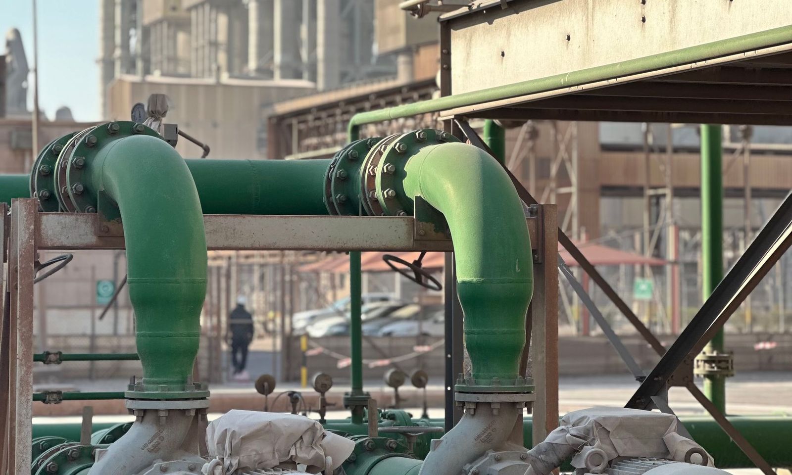 Two pump and motor sets on green pipework in a plant
